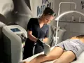 Profesjonalistka wykonuje zabieg depilacji laserowej nogi. To najlepszy laser do depilacji, zapewniający gładkość skóry.
