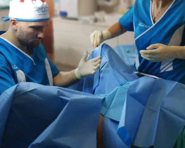 Chirurg i asystentka w rękawiczkach przygotowują się do zabiegu. Zdjęcia nieudana labioplastyka mogą pokazywać takie momenty.