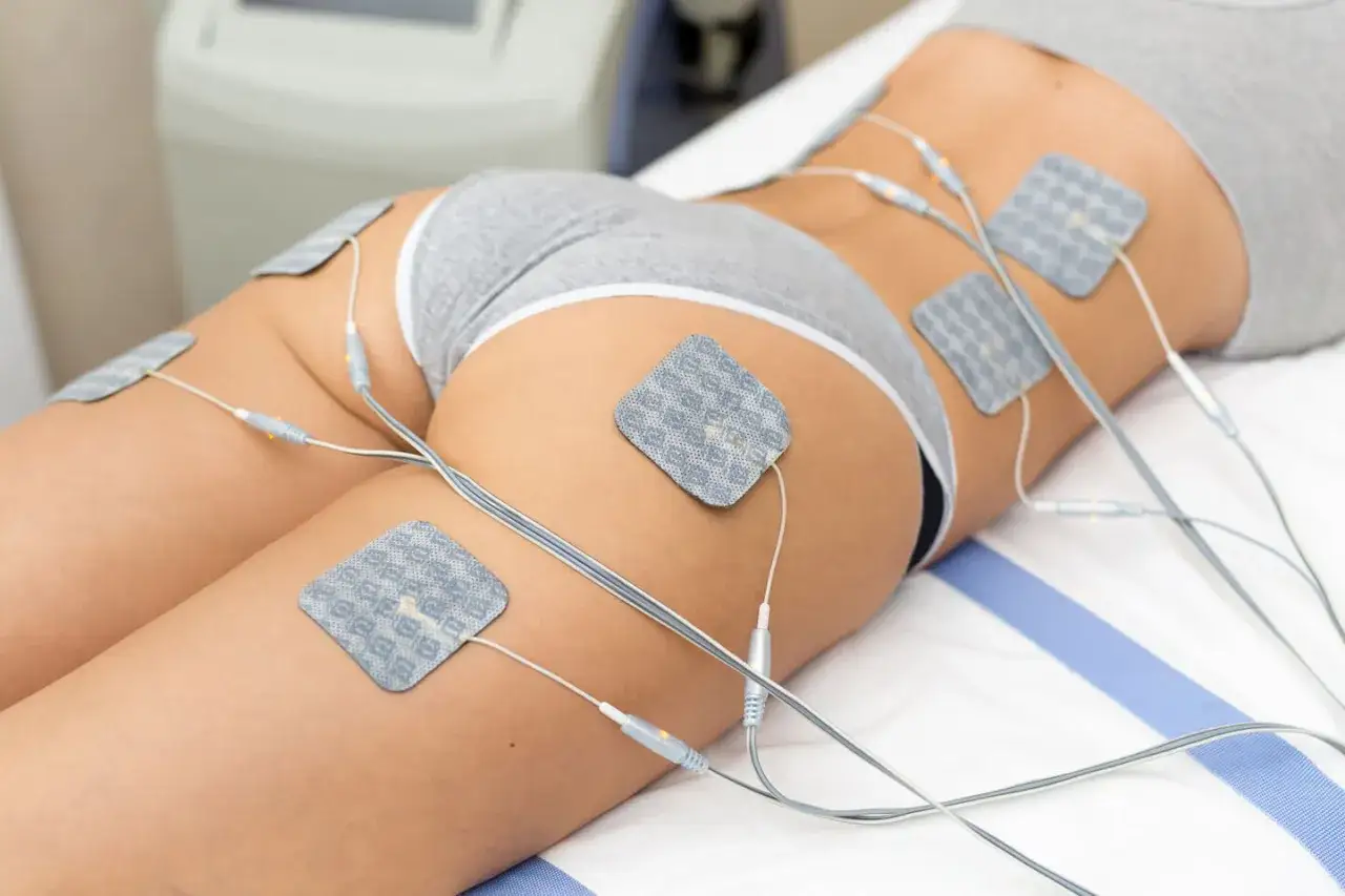 Elektrostymulacja efekty po 10 zabiegach: widoczne elektrody na udach i pośladkach, przygotowanie do zabiegu modelującego sylwetkę.